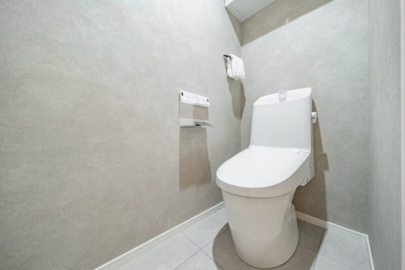 【トイレ】すっきりとしたデザインで清潔感があり、落ち着ける空間。トイレは温水洗浄機能付きです。吊戸棚も設置されており、トイレットペーパーなどが収納できます。